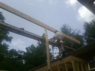 Carpenter setting a ridge beam over a new addition frame — Ice Dam Removal by Roofing Brothers in Fort Valley