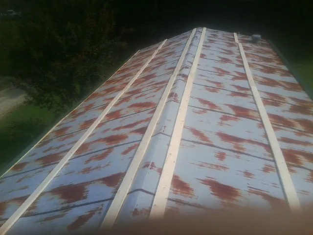 Rusted metal roof panels with new wood purlins before replacement — Storm Damage Roof Repair in Fort Valley by Roofing Brothers