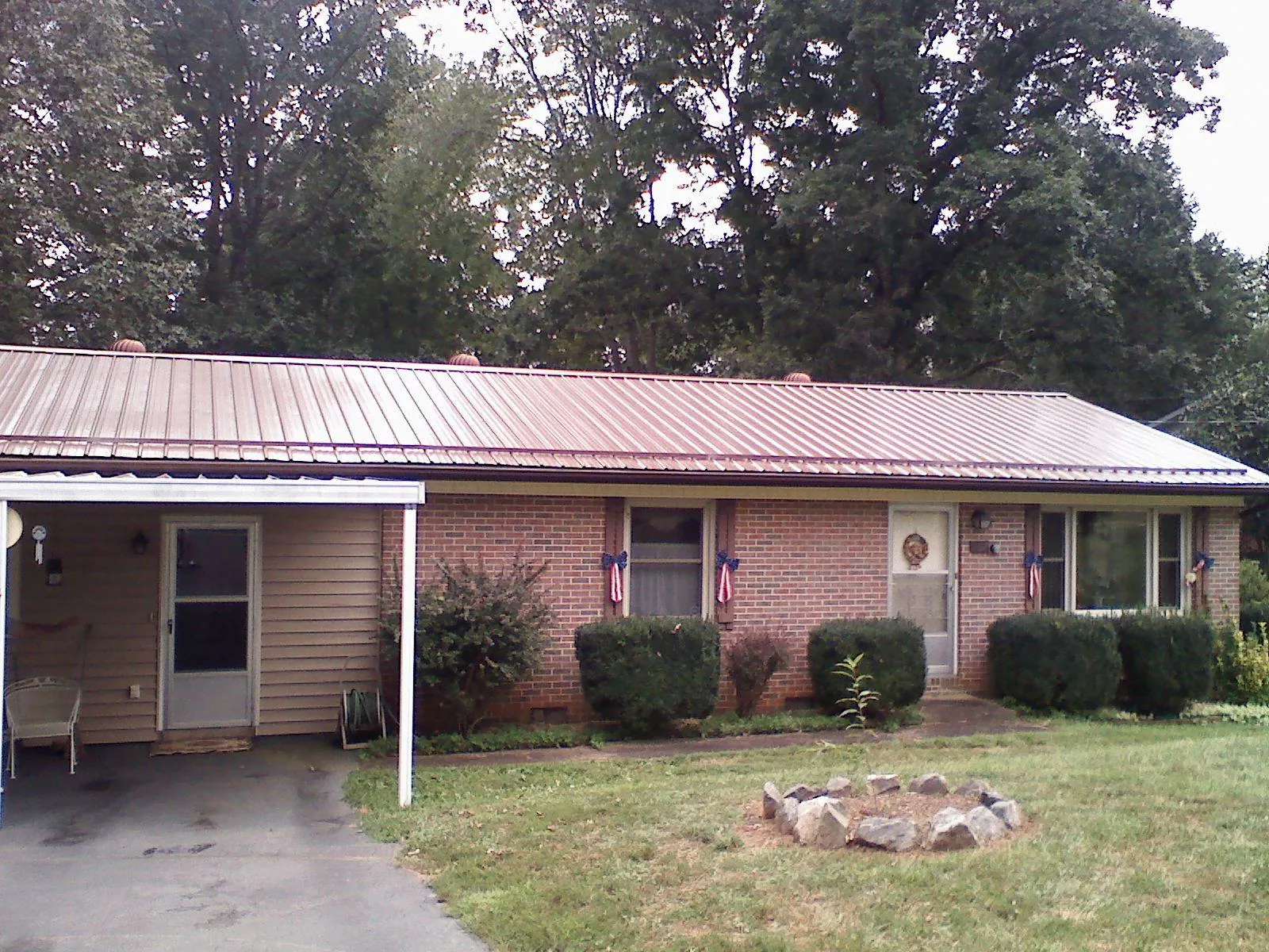 Bronze metal roof and carport on a brick ranch home — Roof Repair work by our crew in Fort Valley