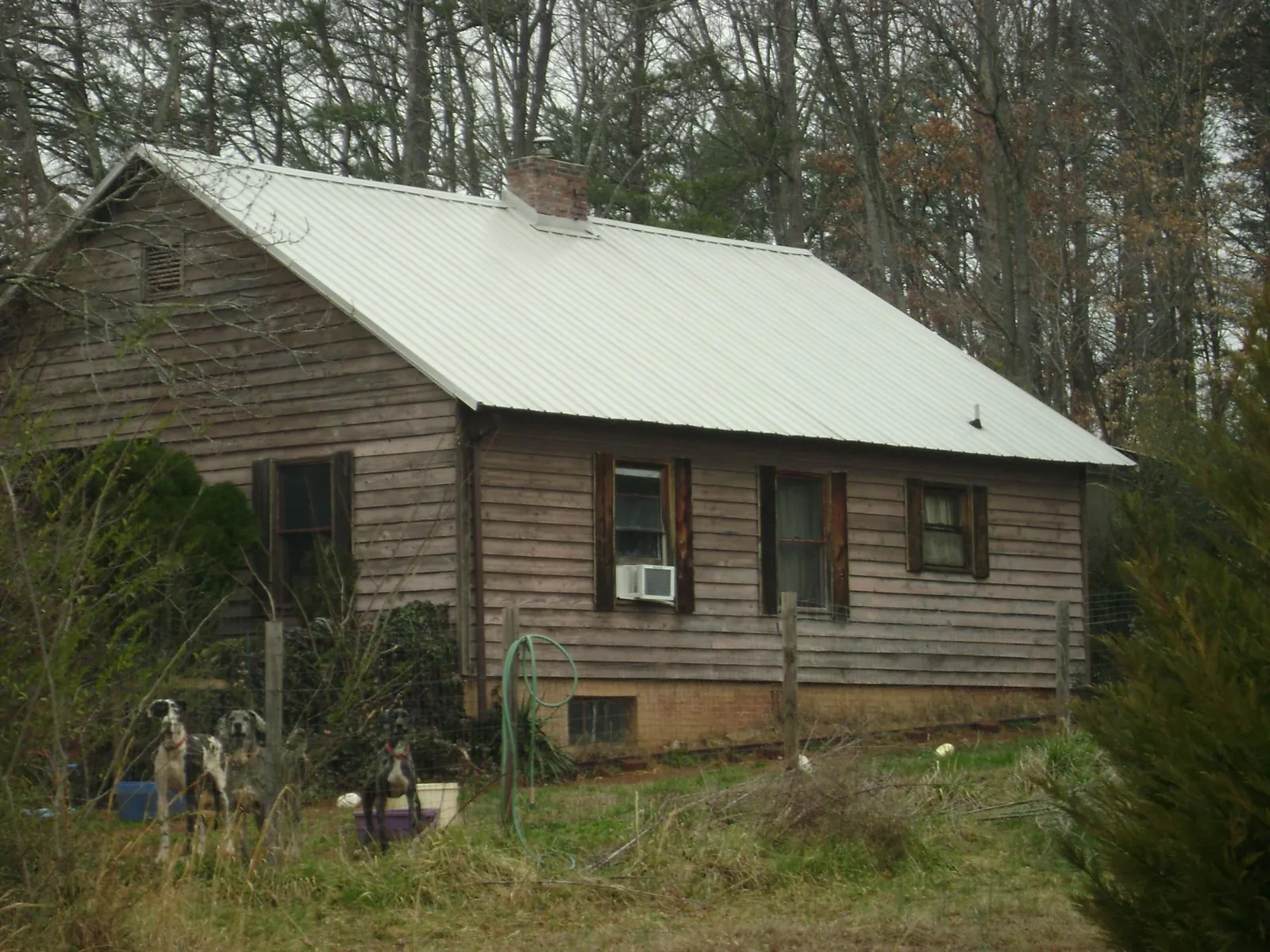 White metal roof on an old wood sided farmhouse, from a Metal Roof Installation job in Fort Valley